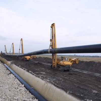 Heavy duty construction machines carrying and placing gas pipe into the ground. Heavy duty construction machines carrying and placing gas pipe into the ground.